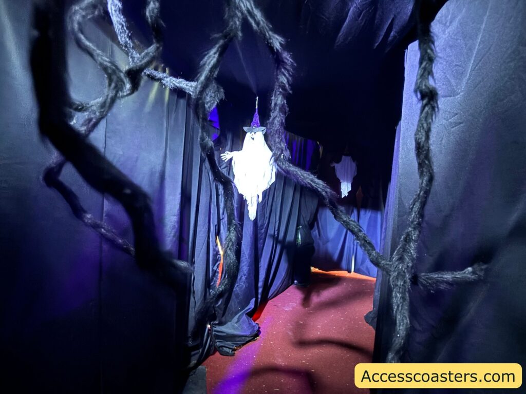 black coridor with curten and halloween decorations hanging from the celing
