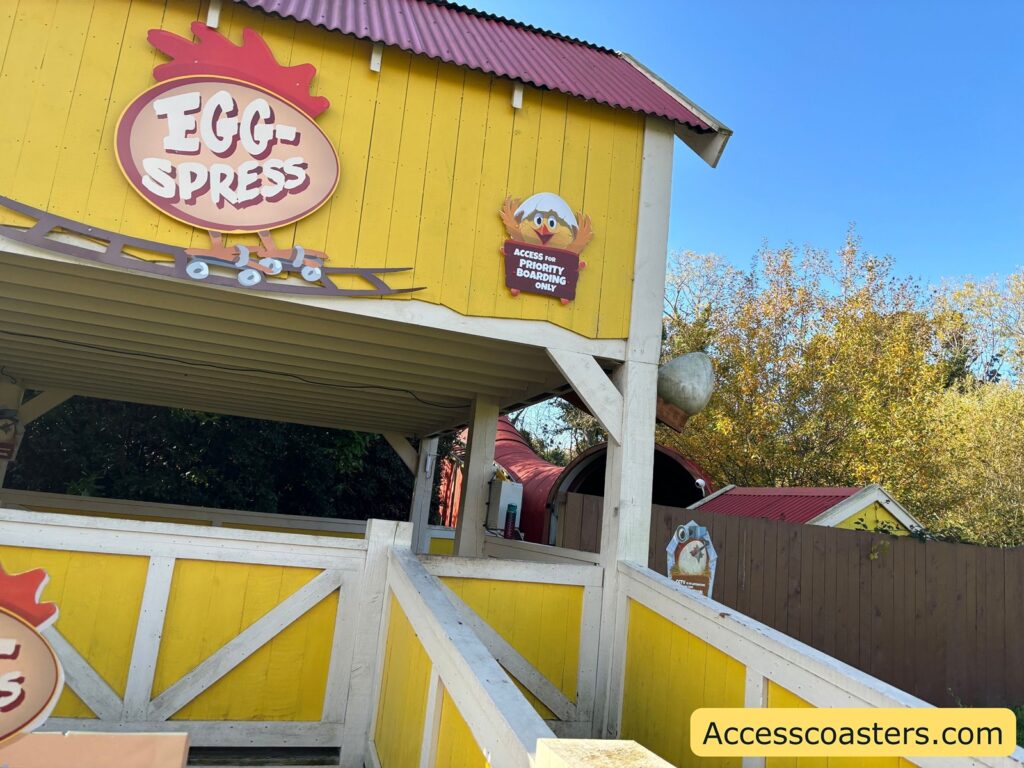 ride acccess pass entrance to egg spress rollerocaster with ramp and direction signage 

