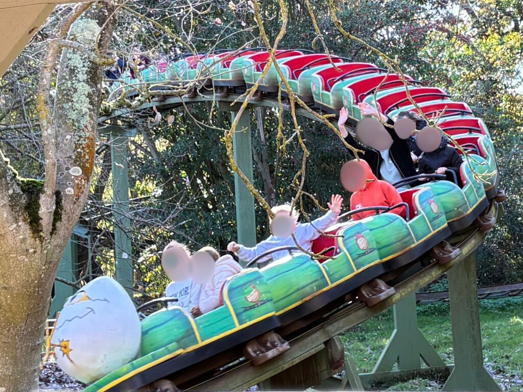 Egg Spress rollercoaster climbing a track bend surrounded by greenery.