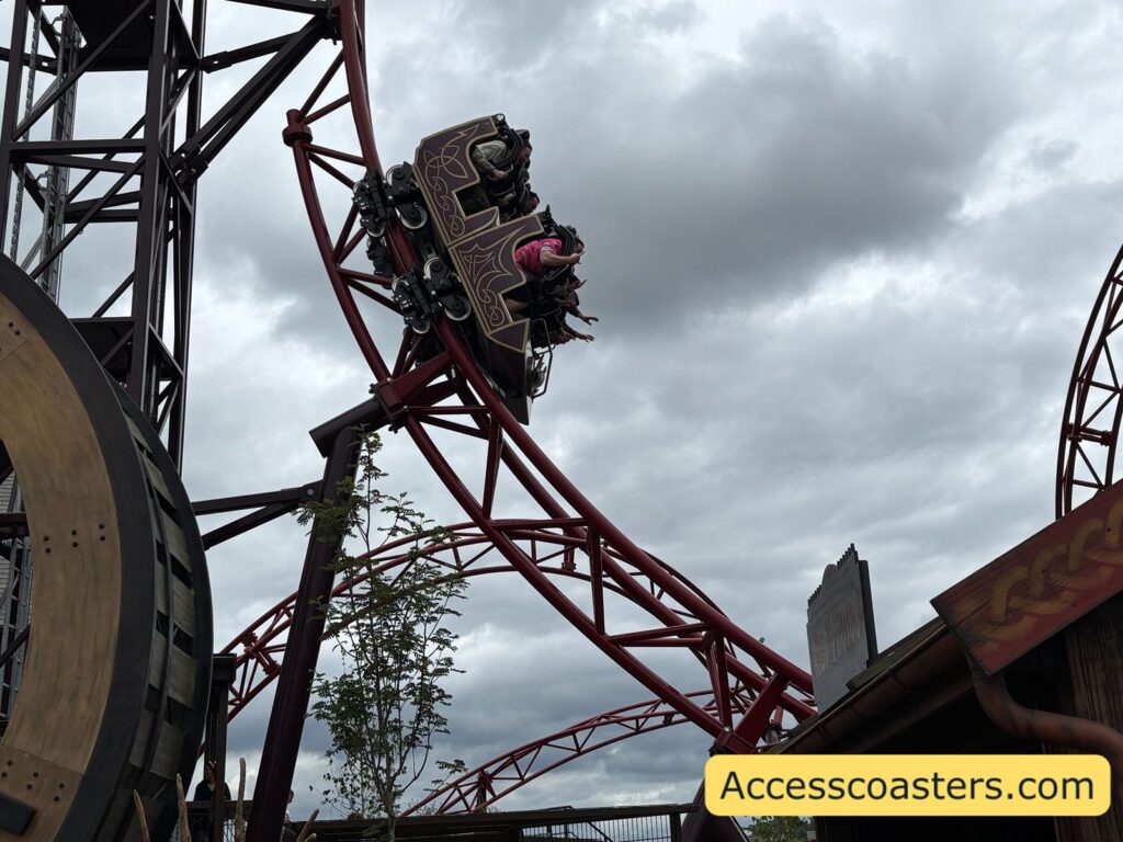 Image of Drakon train at an angle going down first drop in the background you can see the rest of the ride track. 