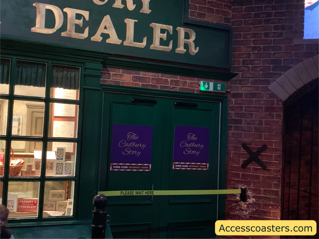 Image of the entrance to Cadbury story. The doors are green and closed until the show starts. There is a sign saying Cadbury story 
