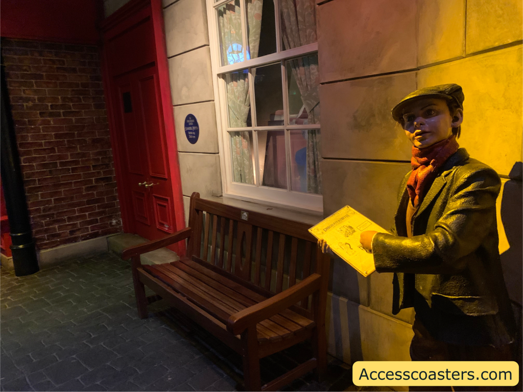 Image of bench where you can sit and wait for the show. There is a structure of a Victorian boy next to the bench. 
