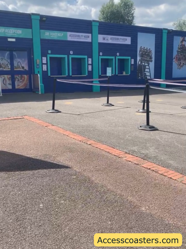 Image of accessibility kiosk at Thorpe Park in the image you can see a queue line with 3 serving points at the ride access pass kiosk. 