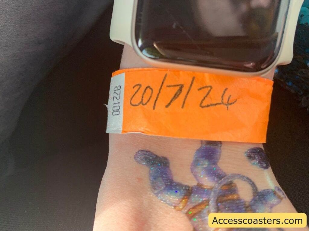 Image of orange wristband on wrist with the date written on it 