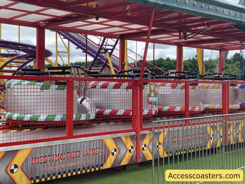 image of station for wild mouse coaster. in the image you can 4 ride carts all lined up in the station waiting for riders 