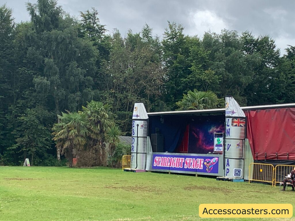 in the image you can see an outdoor stage with a sign saying starlight stage 