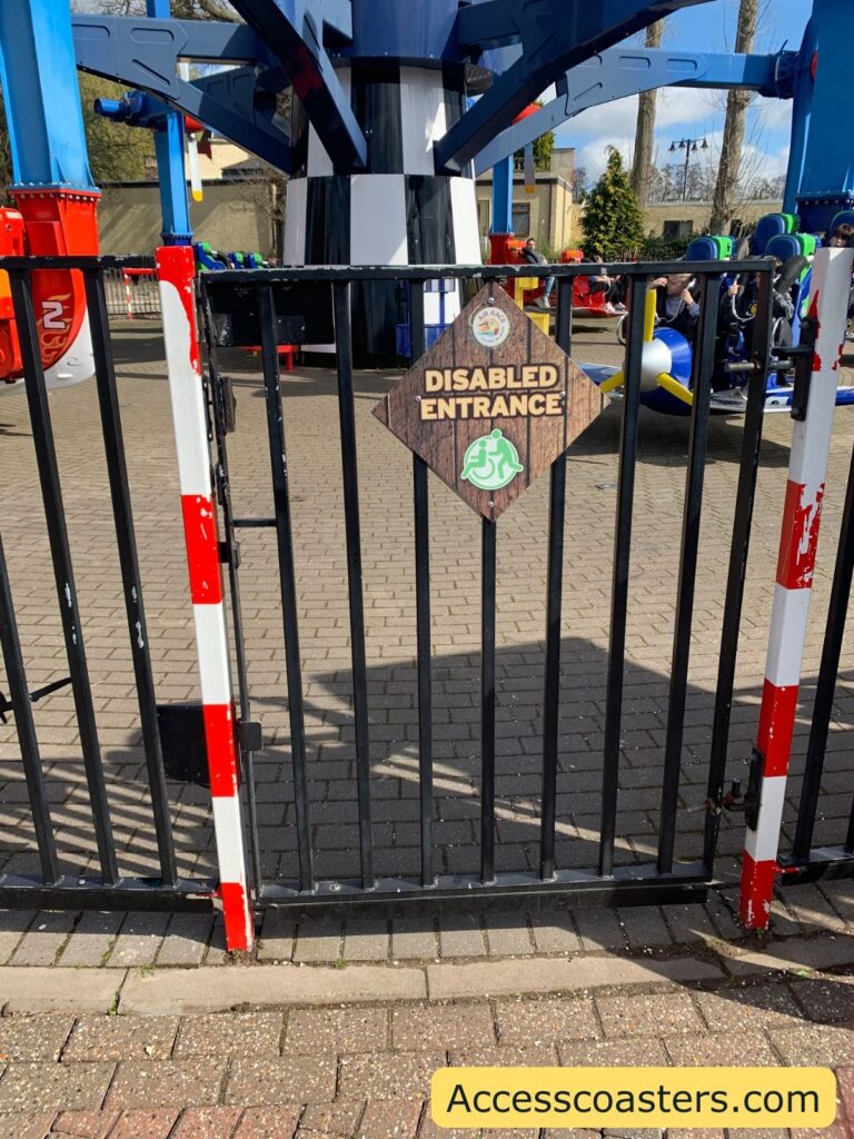 in the image you can see a gate with a sign on that reads disabled access. behind the gate you can see air racer ride area