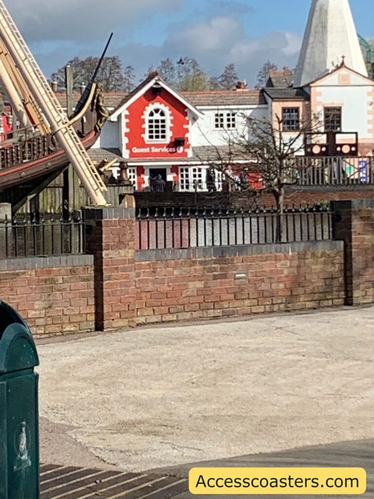 in the image you can see a pirate ship ride and then a lake in the distance you can see the guest services building