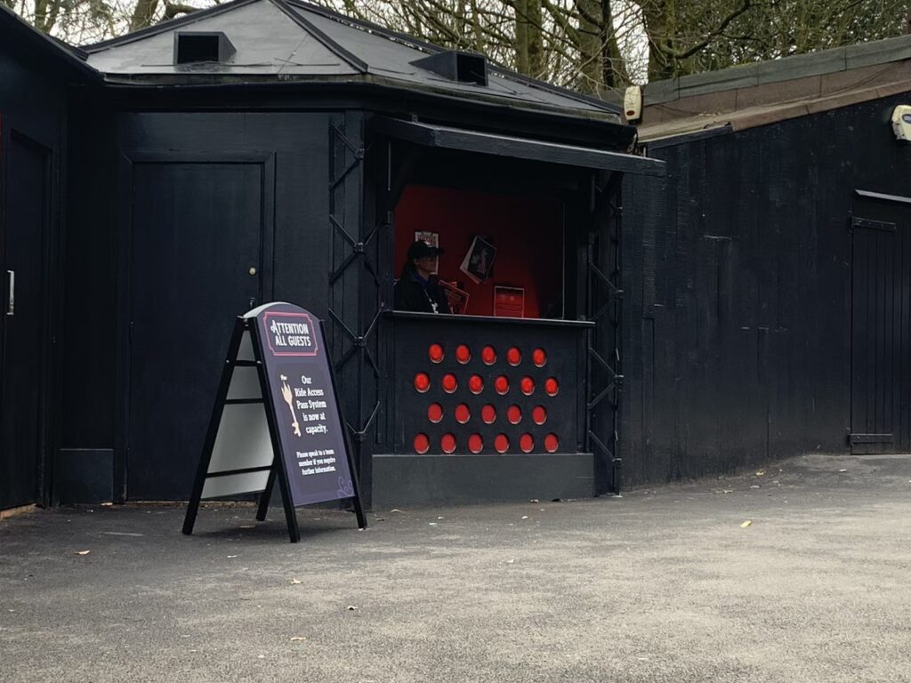 image shows a small kiosk style of building with black and red theming. this is the guest services hub in forbidden valley.