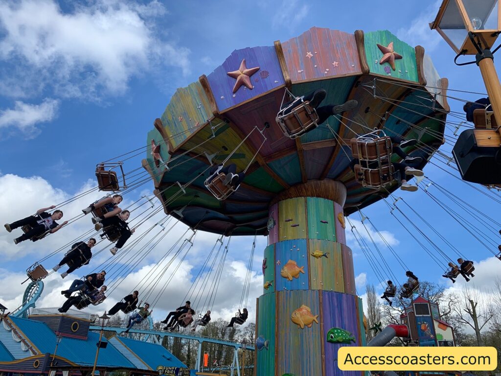 image shows wave swinger during a cycle the chairs and high up in the air. 