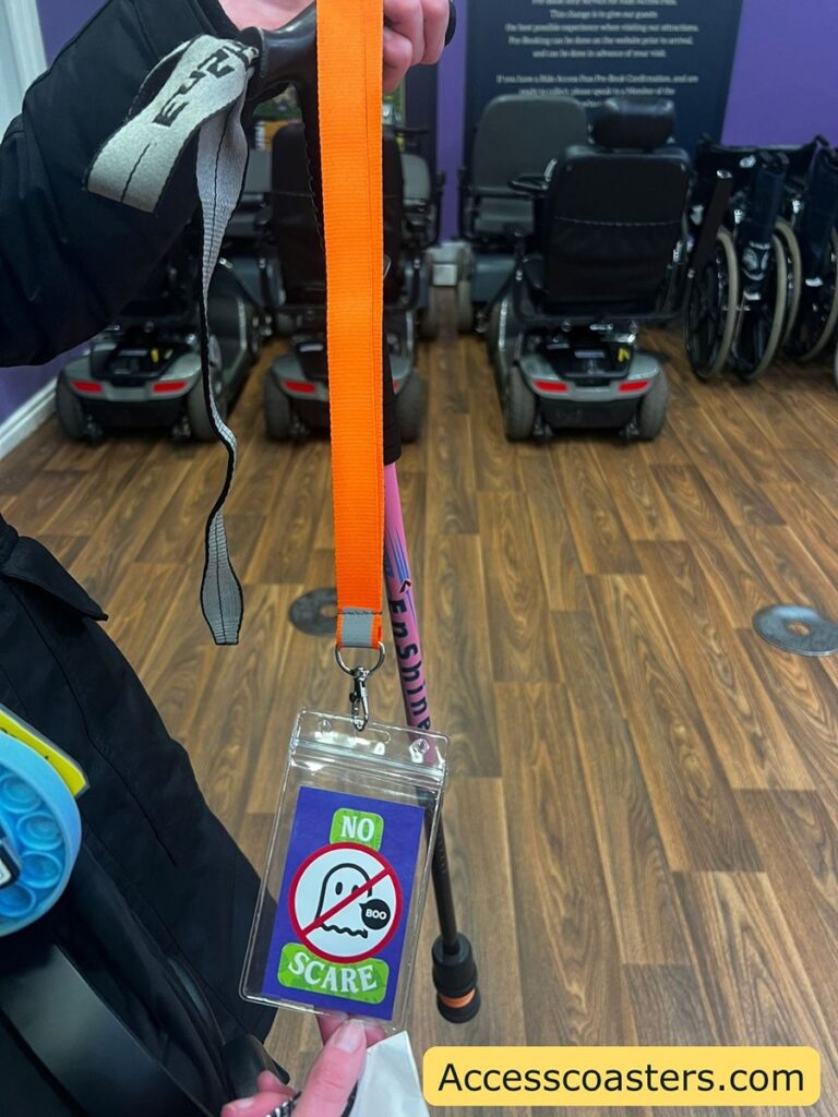 image shows a orange lanyard with a card on the bottem that says no scare with a ghost image that has a cross though it
