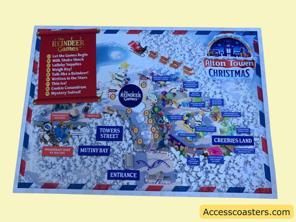 The image is a map of Alton Towers Christmas event, featuring "The Reindeer Games." The map is decorated with snow and festive elements. On the left side, there is a red banner listing the activities of The Reindeer Games, which include:
1. Let the Games Begin
2. Milk Shake Shack
3. Lullaby Supplies
4. Weigh Hey!
5. Talk like a Reindeer!
6. Written in the Stars
7. Thin Ice!
8. Cookie Conundrum
9. Mystery Solved!
The map shows various attractions and areas within the park, such as Towers Street, Mutiny Bay, and CBeebies Land. Some attractions listed are Marauder's Mayhem, Sharkbait Reef by Sea Life, Postman Pat Parcel Post, and Go Jetters Vroomster Zoom Ride. The map also includes a start and finish point for The Reindeer Games. The top right corner features the Alton Towers Christmas logo with a snowy background. The bottom right corner has the text "Accesscoasters.com" on a yellow background.