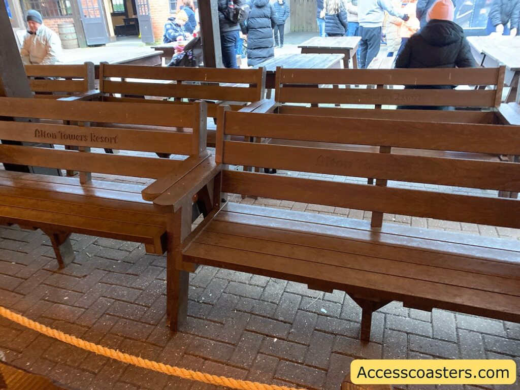 in the image you can see two rows of brown benches with backs