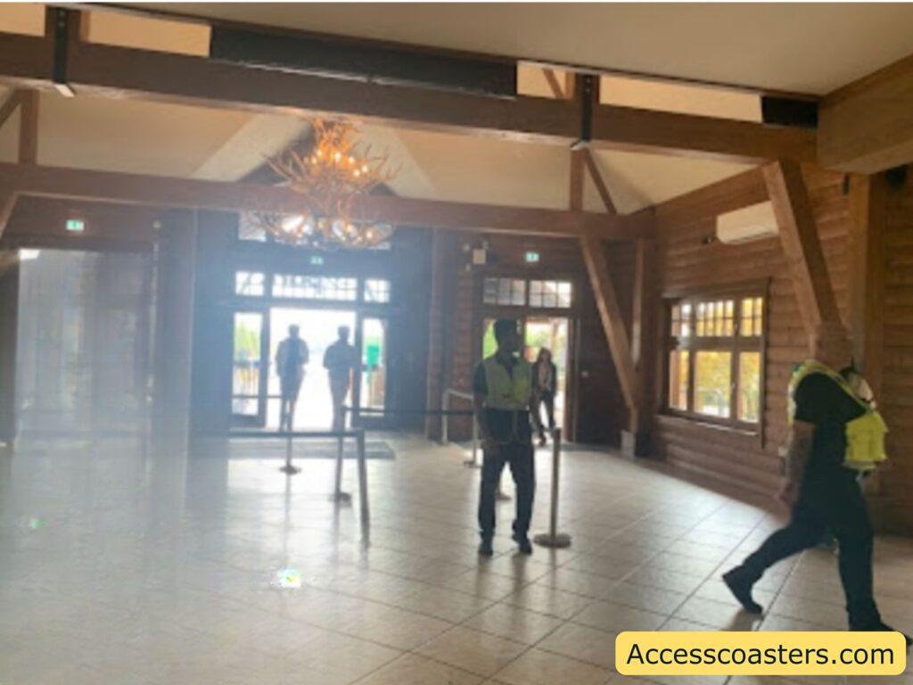 entrance hall with high wooden beams, large windows, and a tiled floor. 