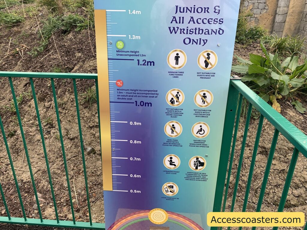 Height measurement board at an amusement park. The board is used to check if guests meet the minimum height requirements for a ride. There is a vertical ruler on the left, marked from 0.5 meters to 1.4 meters. At 1.2 meters, it says "Minimum Height Unaccompanied 1.2m." At 1.0 meter, it says "Minimum Height Accompanied 1.0m – must be accompanied by an adult and sit on inner seat of double seat."

On the right, there are several circular icons with rules and restrictions, including:
- Minimum three functioning limbs required
- Not suitable for guests who are pregnant
- Not suitable for guests with a health condition or injury
- Not suitable for guests with a cast/splint/arm boot/brace
- Non-fixed prosthetics/mobility devices: please see operator
- Suitable for permanent wheelchairs: please see operator
- Lapbar/restraint must close
- Guests must be able to hold themselves upright and brace as required
- Loose items must be removed
