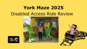 bright yellow presentation slide with the title "York Maze Disabled Access Ride Review" in large black text. In the center, there is a photo of a smiling Iona standing between two people in large, cheerful corn cob costumes—one with a pink bow and shoes, the other with a big red mouth. The background of the photo shows a wooden building with sunflowers. On the left side of the slide, there is a black accessibility icon with a globe. On the right, there is a cartoon of Iona with glasses and headphones, arms raised, riding a roller coaster.