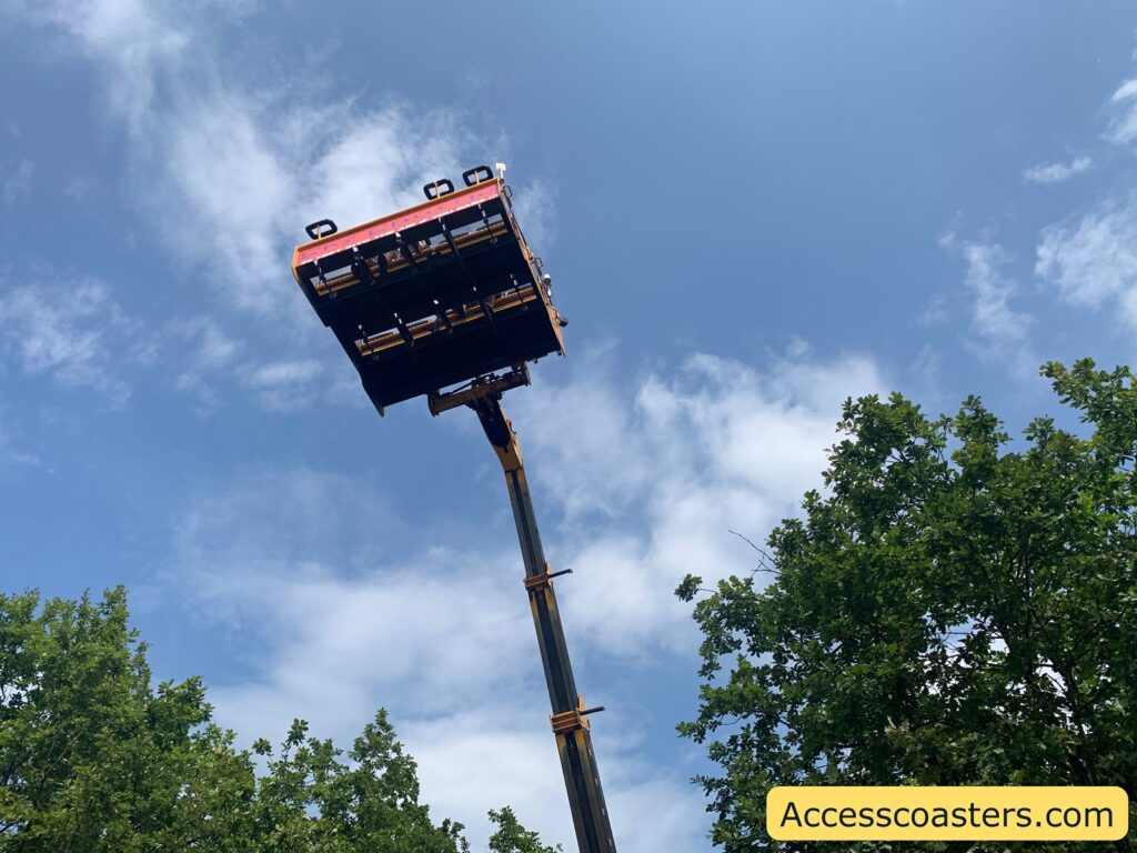Amusement ride platform extended high into the sky, viewed from below. The platform is held up by a long mechanical arm