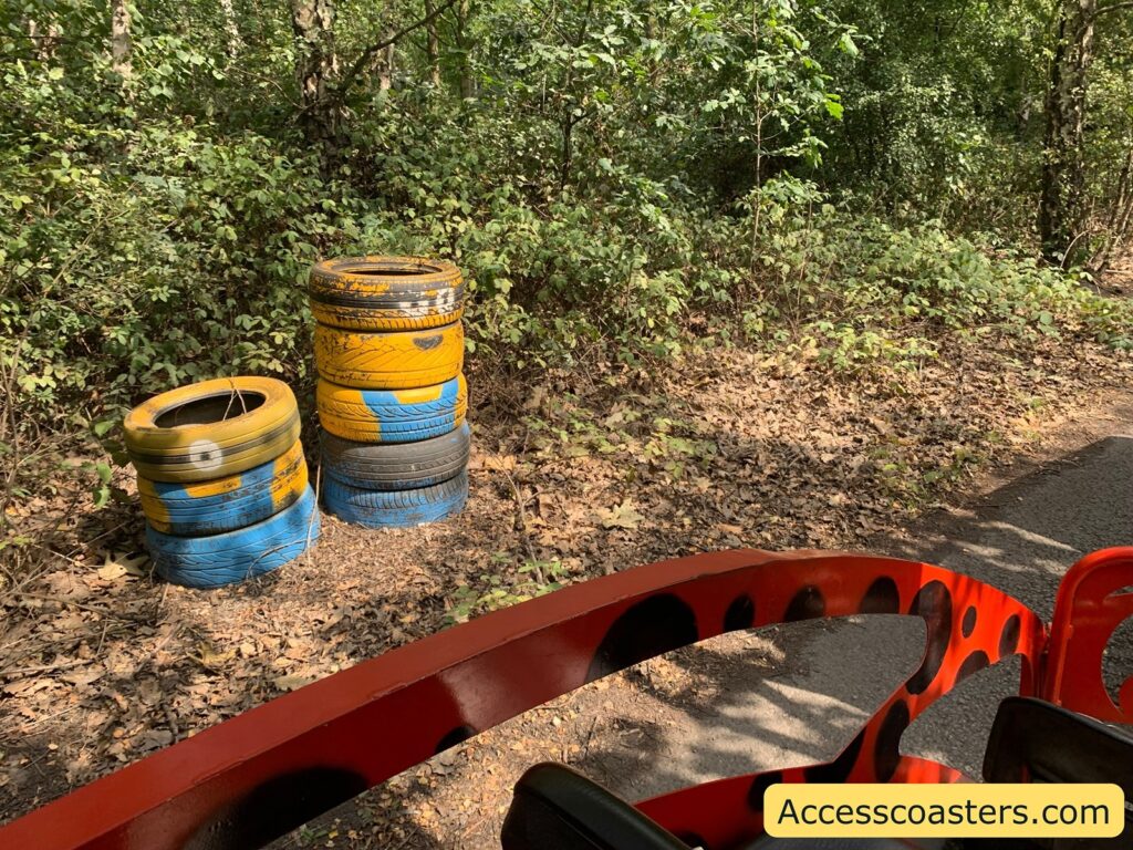 2 stacks of tires painted to look lite minions at the side of the train ride