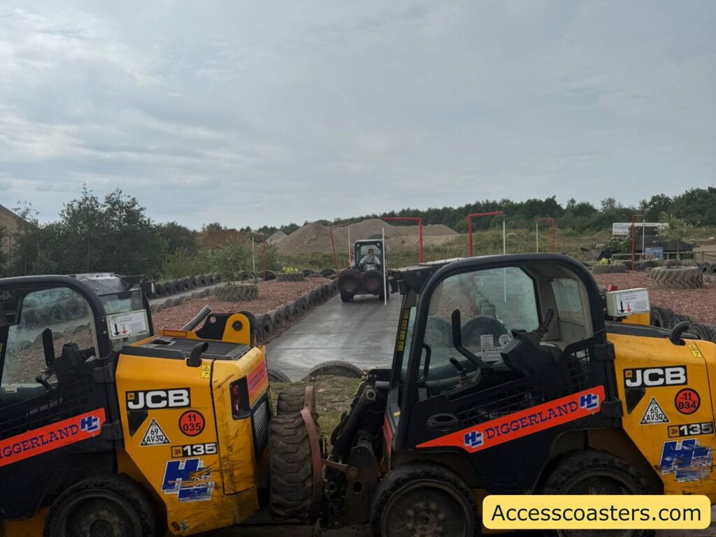 ronot diggers are parked next to each other in the foreground, with another similar vehicle visible in the distance on a paved path. The vehicles are branded with "Diggerland" and feature safety and identification stickers.