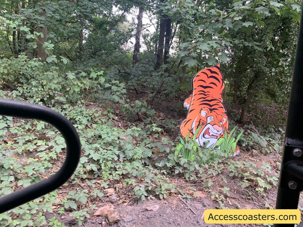 Cartoon tiger cutout in a forested area.