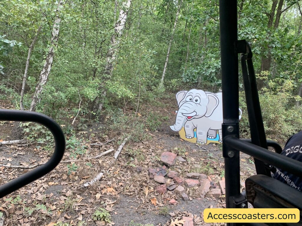 Cartoon elphant cutout in a forested area.