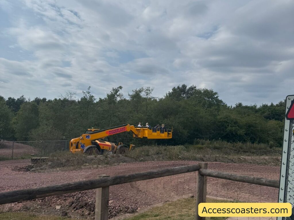 A yellow construction vehicle with a long arm, featuring the word "DIGGERLAND" on its side, is extending outward. Attached to the end is a basket carrying a group of people.