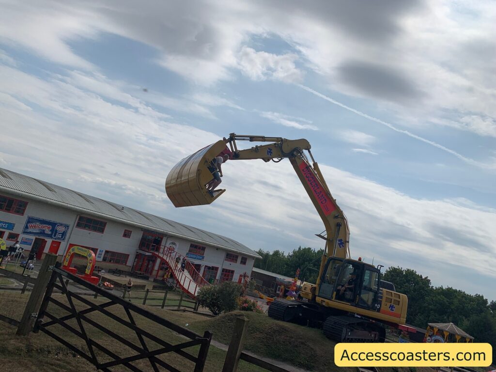 the arm is a modified bucket holding two people like an amusement ride, raised high in the air.