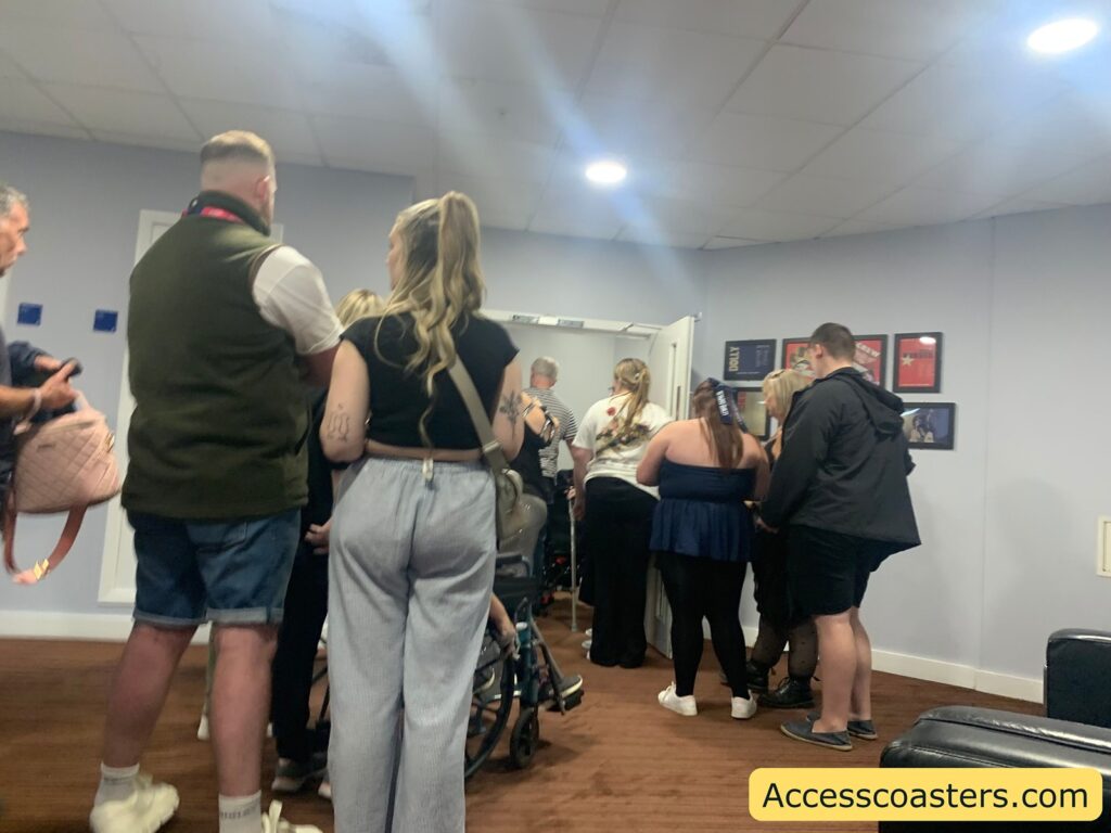 A group of people standing in a queue indoors. The waiting area for lift in reception