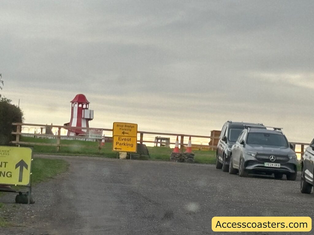 Parking field near entrance with vehicles parked on grass for blue badge holders.