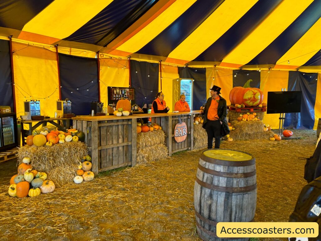 The inside of the marquee, decorated with yellow and blue stripes, pumpkins, and a wooden bar.