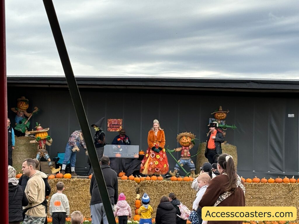 Audience members watch and participate in activities led by costumed characters on a decorated festival stage.