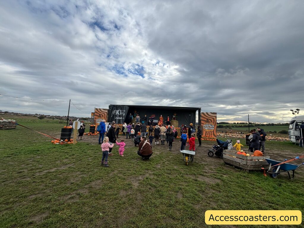 Children and families approach an outdoor festival stage for the Fancy Dress and Character Show