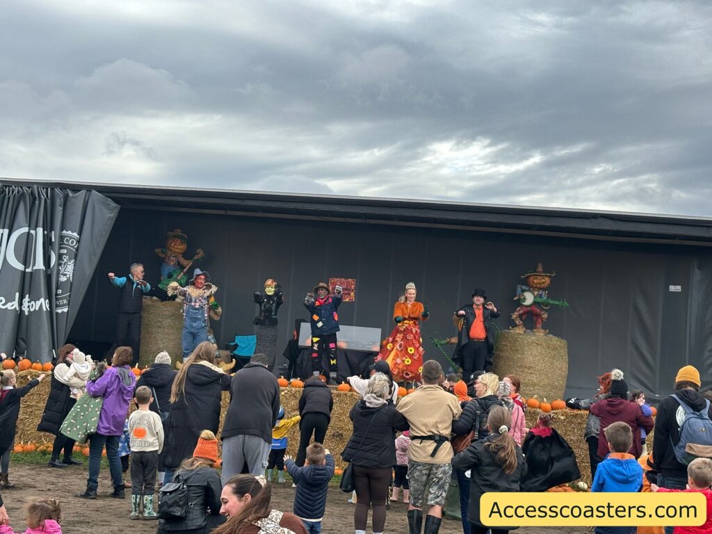 Families and children gather closely in front of the stage, actively participating and dancing along with the Fancy Dress and Character Show performers.
