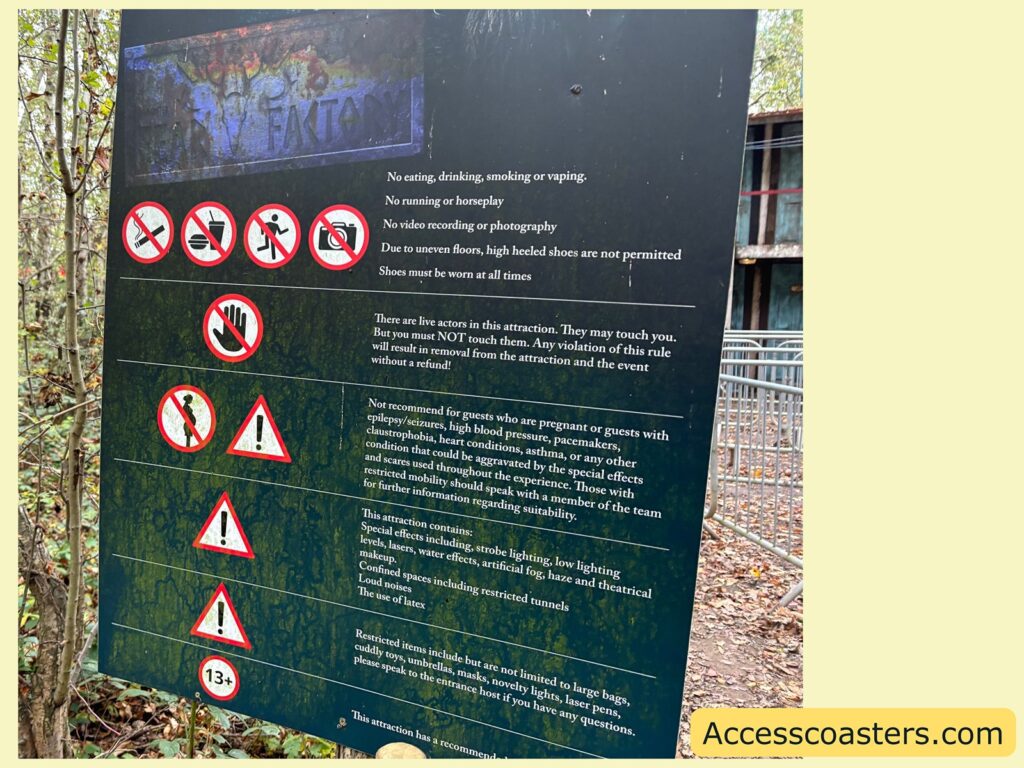 Information signboard outside the Shellton Motel maze with safety icons and guidance for visitors. The board is dark with white text and symbols.