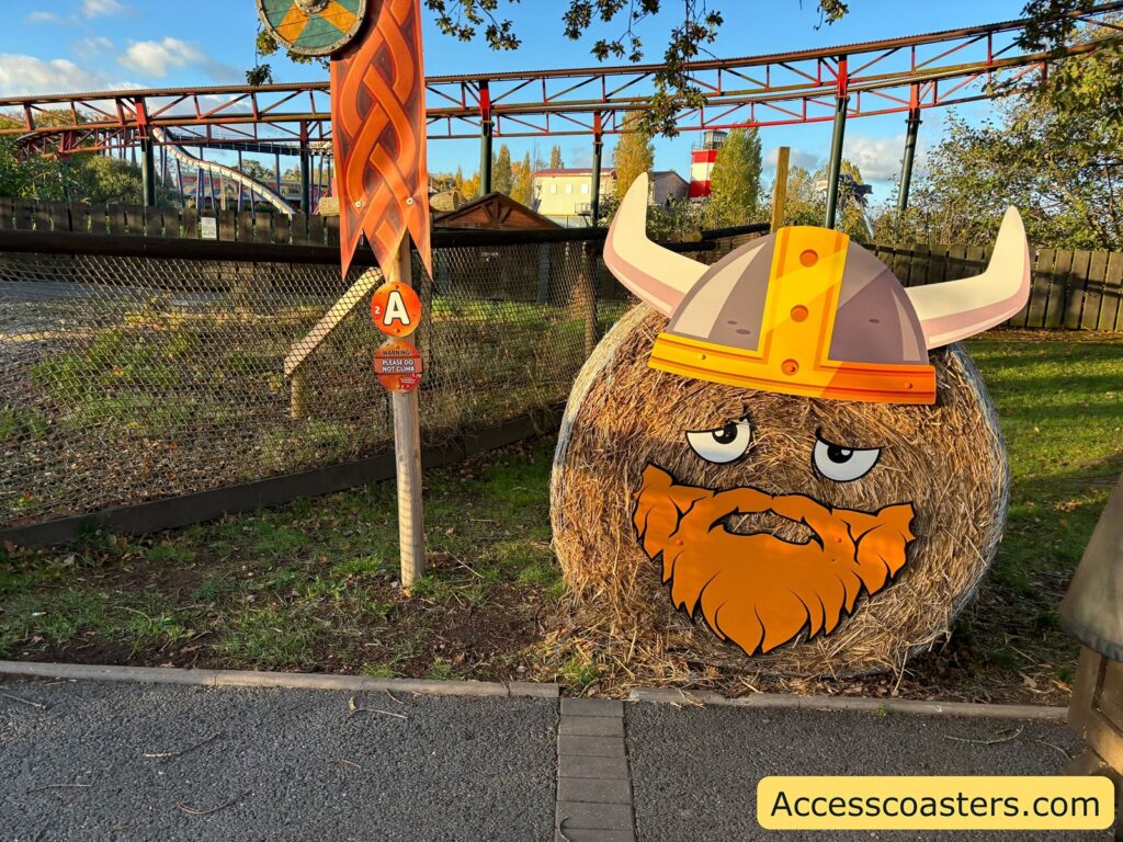 A round hay bale decorated with a cartoon Viking face, complete with a horned helmet and orange beard