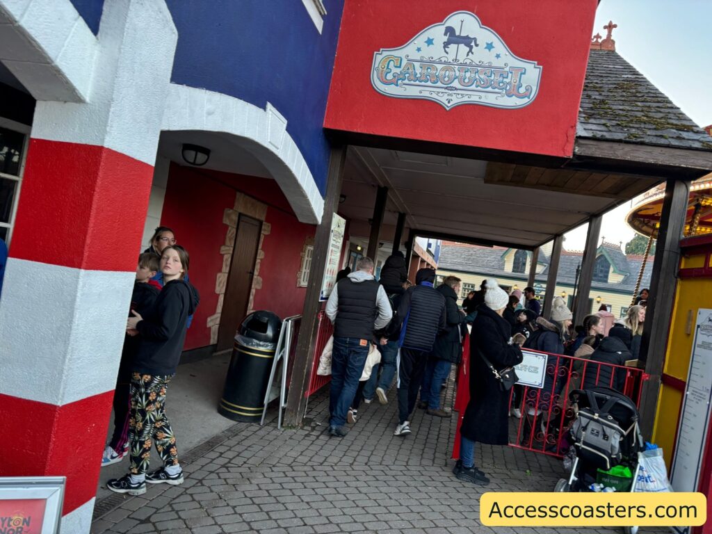 Queue area with visitors lining up under a red striped canopy for the Haunted Express ride.