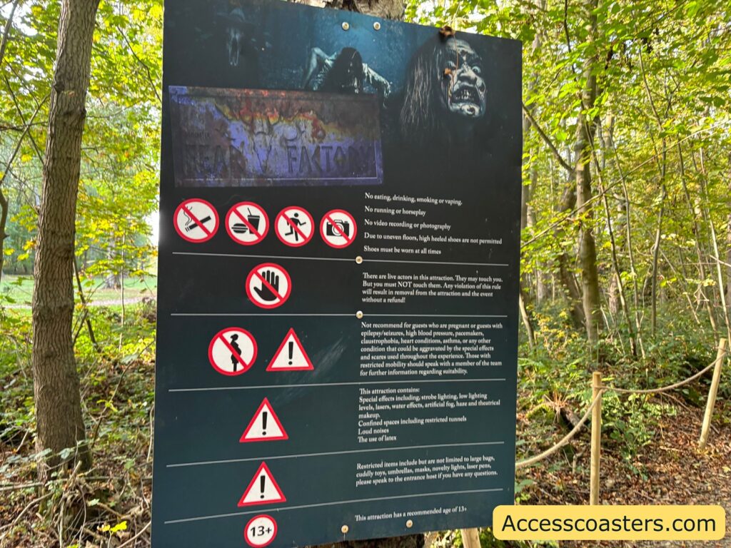 Signboard at the edge of a wooded area displaying safety guidelines and warnings for entering the Quinlens & Co maze.
