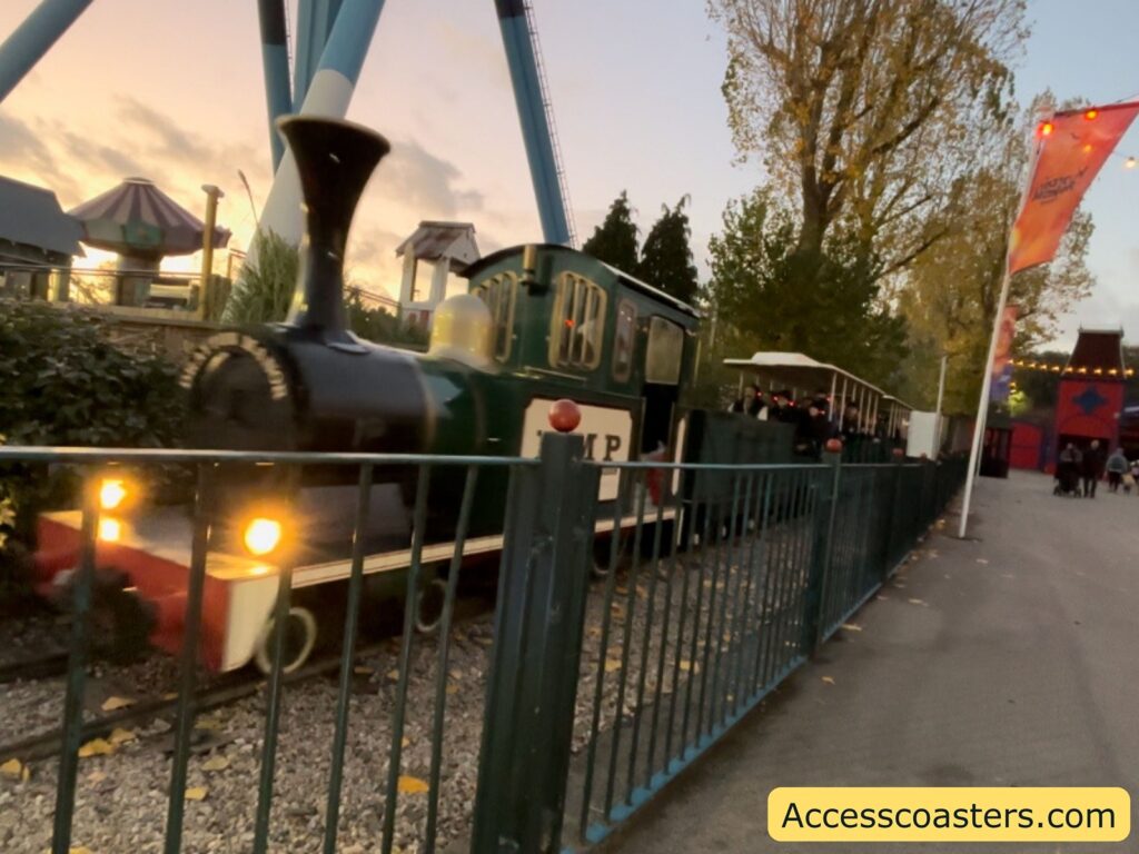 Close-up of the Haunted Express train themed as a black locomotive behind a fence.