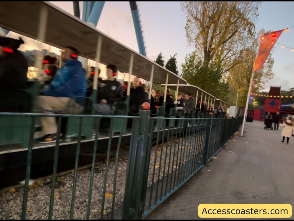 Pathway with guests and a fence next to the Haunted Express train ride.
