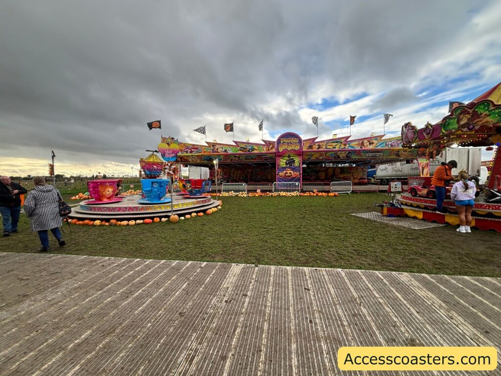 several funfair attractions and stalls on grassy ground 