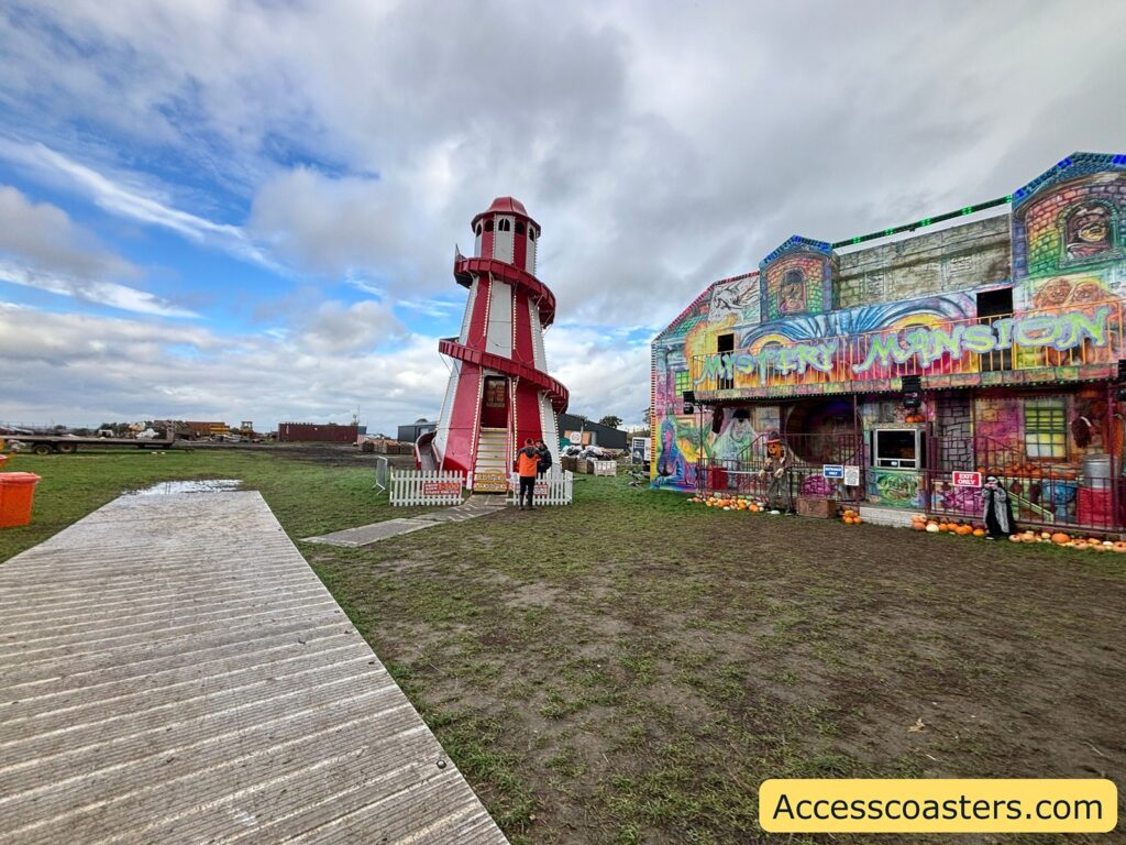 several funfair attractions and stalls on grassy ground 
