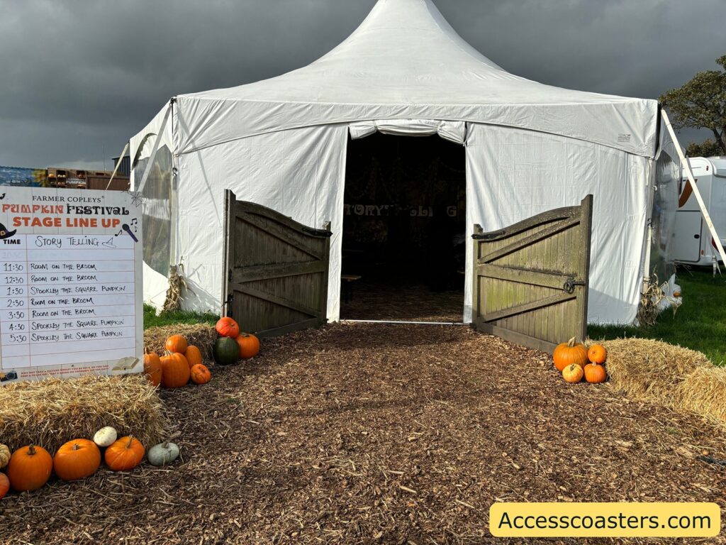 The entrance to a white festival tent, decorated with orange pumpkins