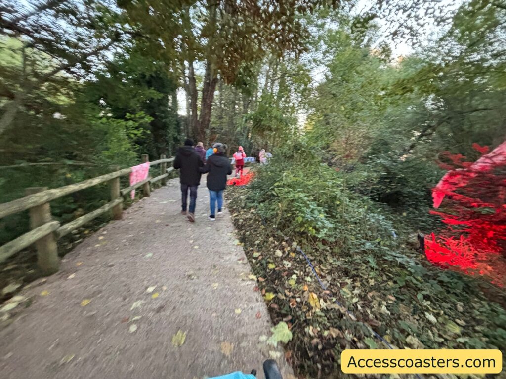  People walking along a paved pathway surrounded by leafy tree