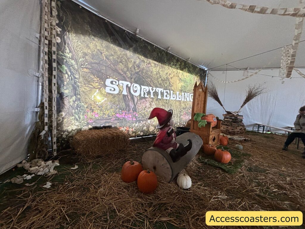 nside the storytelling tent, a cozy scene with pumpkins, straw, and a decorated backdrop that says "STORYTELLING".