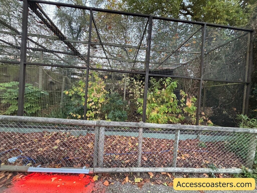 Empty animal enclosure surrounded by wire fencing