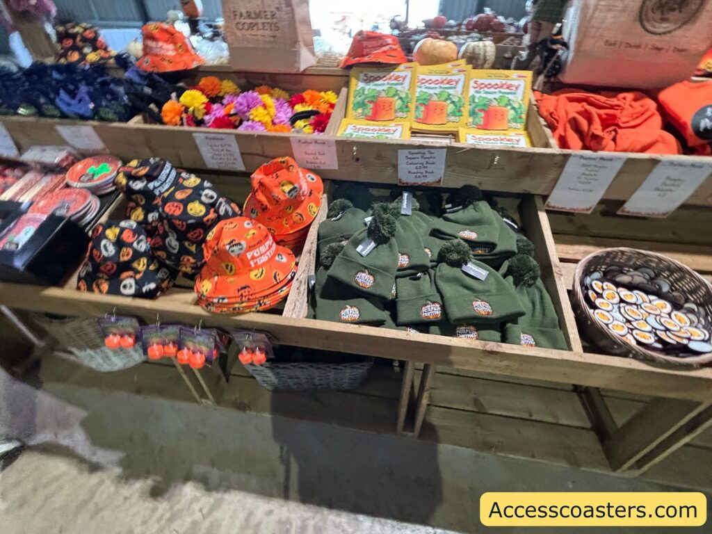 Festival shop tables with orange hats, green items, and souvenirs.