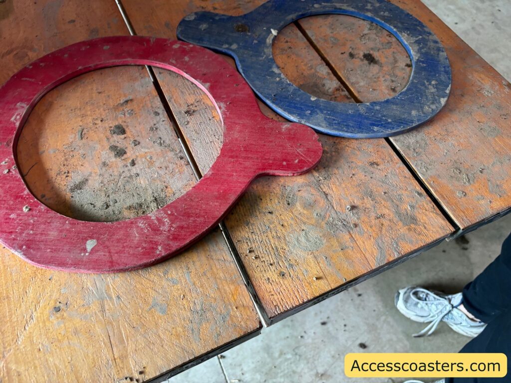 Large red and blue wooden measuring hoops on a table, for sizing pumpkins.
