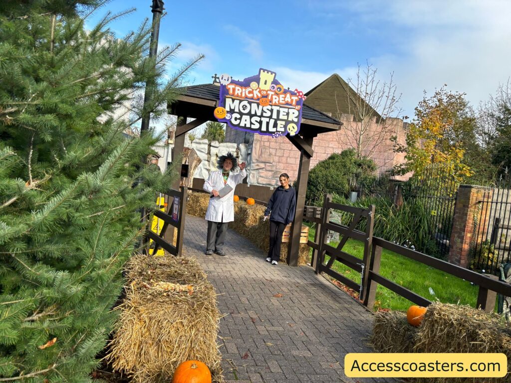 Entrance gate to the “Monster Castle” event, adorned with a themed sign and surrounded by Halloween decorations and trees.