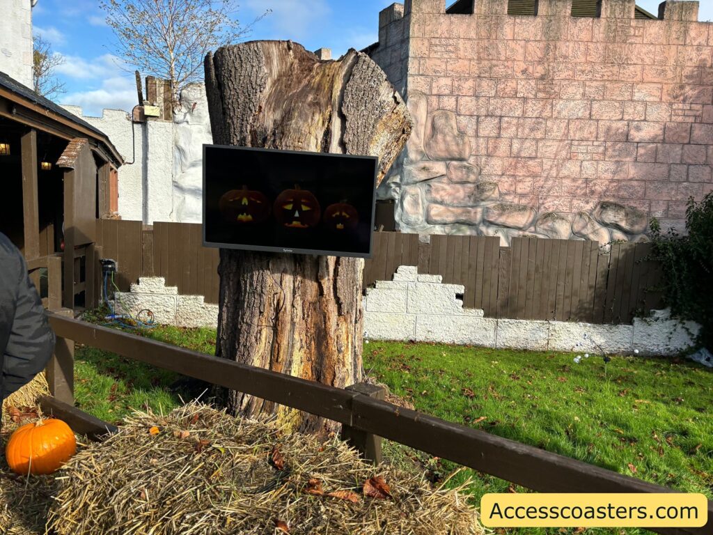 Outdoor castle area featuring a wooden stump and Halloween props
