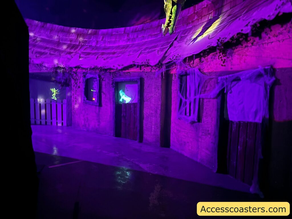 Inside the castle showing a corridor with purple and green lighting, Halloween decorations, and a dark, spooky atmosphere 